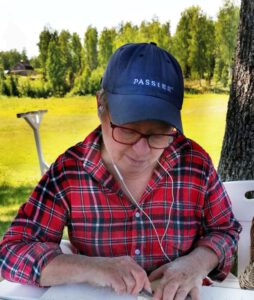 Gitta sitzt am Tisch und schleift Elche aus Holz